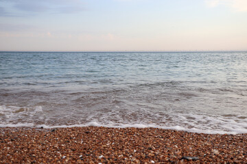 waves on the ocean, rocky beach and bright sky