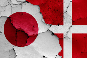flags of Japan and Denmark painted on cracked wall
