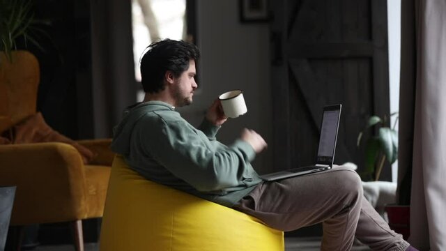 man working on outsource with laptop and drinking a coffee at home