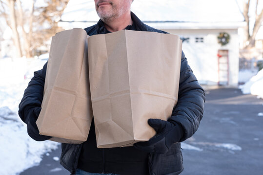 Man Carrying Groceries From The Driveway To The House