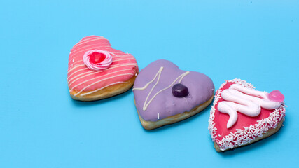An assorted dozen donuts in a box isolated on a blue background