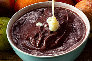Acai (Açai) with Doomed Milk, Brazilian Tradicional Fruit with Tropical Fruits on a Bowl on  Wooden Table 