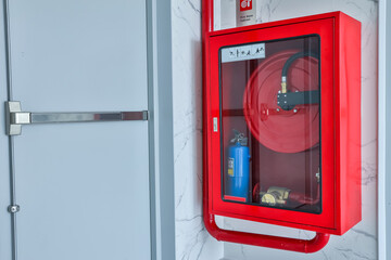 Hydrant with water hoses and fire extinguish equipment. Fire safety equipment in the red box on...