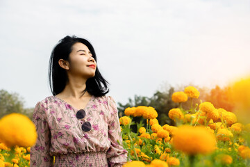 happy Asian beautiful woman breathing  fresh air and happy with beautiful yellow flower field...