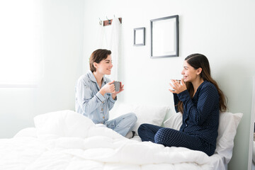 Beautiful friends in pajamas gossiping in the morning