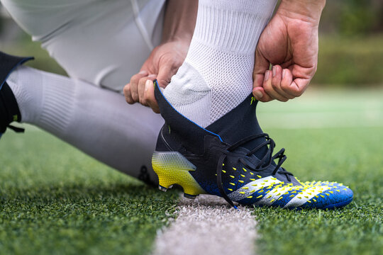 Bangkok, Thailand - January 2021 : A football player is wearing adidas "Predator Freak" which is design for striker feature on turf training ground. Close-up and selective focus, sport action photo.