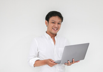 Young asian man is smile and enjoy when working at home with laptop computer. Work from home concept.