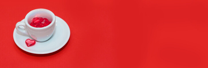 cup with hearts on a red background. the view from the top. red hearts spilled out. isolated on a pink background. copy space