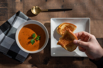 Overhead view of a grilled cheese sandwich with tomato soup
