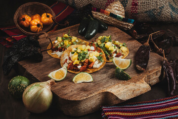 Bodegón de una deliciosa comida mexicana con chiles y vegetales al rededor en una tabla de madera