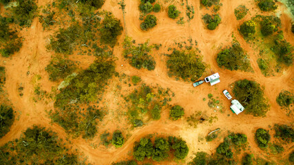 Vertical aerial view of two 4WD's with modern caravan parked at a free camping area in the outback in Australia.