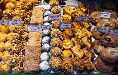 Showcase of Spanish pastry shop full of various appetizing sweet confectioneries. Price tags with...