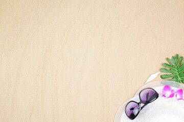 top view travel beach background concept with sunglasses and beach hat on sand.