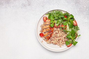 Turkey fillet or chicken, quinoa and vegetable salad in plate. Diet concept food. Top view.