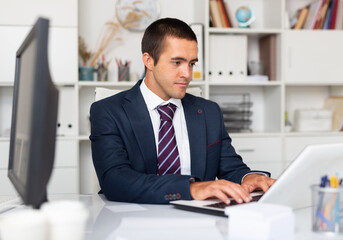 Professional business man using laptop at workplace in office