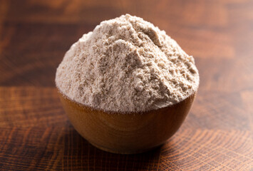Fototapeta na wymiar Spelt Flour in a Wooden Bowl on a Wooden Butchers Block