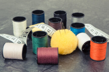 Accessories and tools for using in sewing. Spools of thread, needle and tape measure