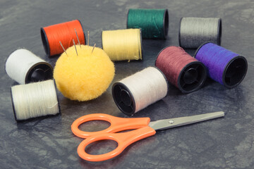 Accessories and tools for using in sewing. Spools of thread, needle, scissors