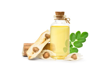 Moringa Oil in glass bottle with dried seeds and green leaf isolated on white background.