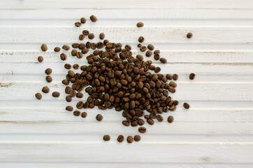 coffee beans scattered on white wooden background