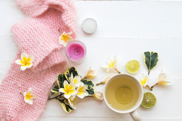herbal honey lemon healthy drinks health care for sore throat with pink  knitting wool scarf  of lifestyle woman relax in winter season and flowers frangipani decorate on background white wooden