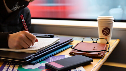 Schoolboy with mask does schoolwork on the ICE fast train