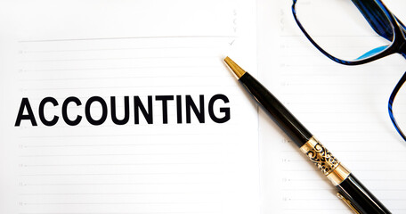 In the diary of accounting tectonics, a pen and glasses are nearby.