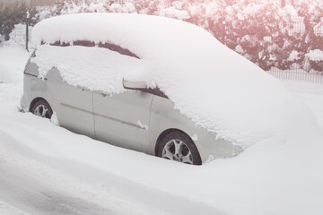 Car covered with heavy winter snow. Uncleaned car buried in winter snow.