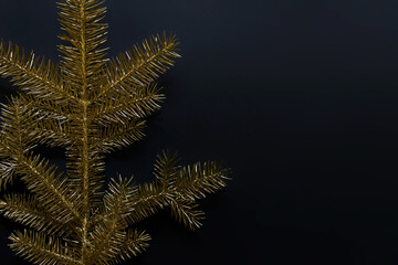 Golden Christmas tree color with metallic paint on black background. Photo with copy blank space.