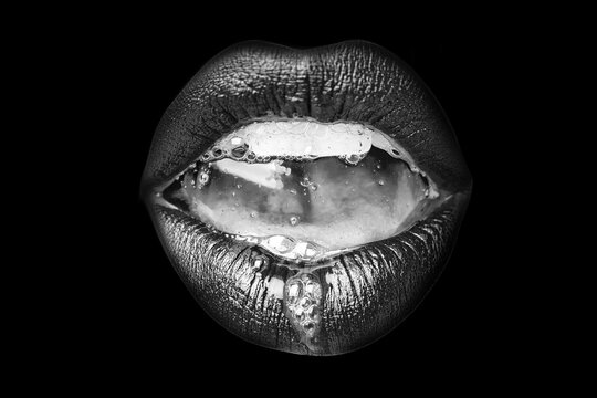 Saliva in the mouth. Female open mouth with sexy lips and teeth closeup on black background.