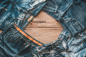 Several jeans are placed on the wooden floor.