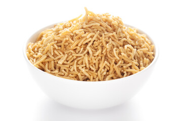 Salty plane Bhujia in a white ceramic  bowl, made with Chickpeas or gram flour (Besan). Pile of Indian salty snacks (Namkeen), under backlight, side view