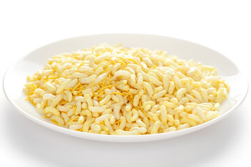 Crunchy Lemon Bhel in a white ceramic  plate made with Puffed Rice small besan sev. Pile of Indian spicy snacks (Namkeen)  under backlight side view 