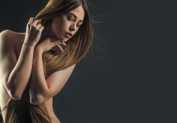 Sexy woman with long healthy hair and naked body on black background, beauty salon