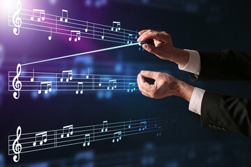 Hands of male conductor on dark background