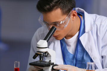 Male scientist working with microscope in laboratory