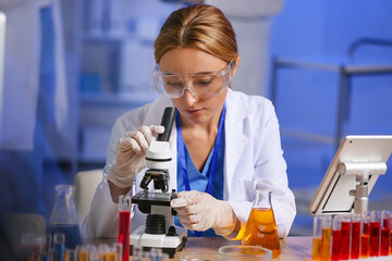 Female scientist working with microscope in laboratory