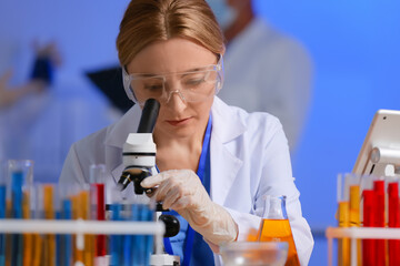 Female scientist working with microscope in laboratory