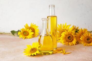 Bottles of sunflower oil on color background