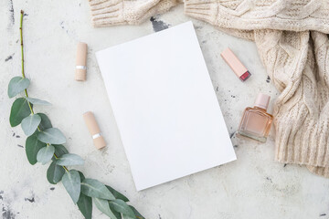 Blank magazine, lipsticks and perfume on light background