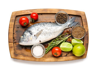 Board with raw dorado fish and ingredients on white background