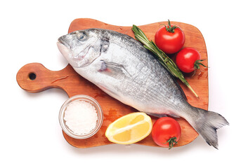 Board with raw dorado fish and ingredients on white background
