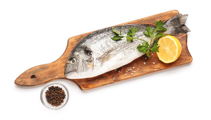 Board with raw dorado fish and ingredients on white background