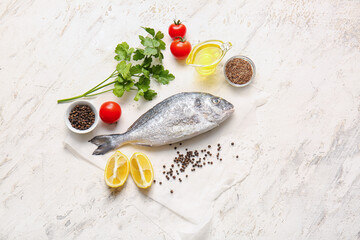 Raw dorado fish with ingredients on light background