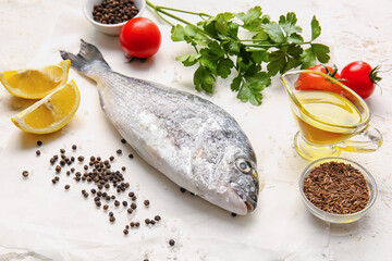 Raw dorado fish with ingredients on light background