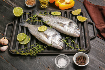 Raw dorado fish with ingredients on wooden background