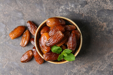 Bowl with sweet dates on table