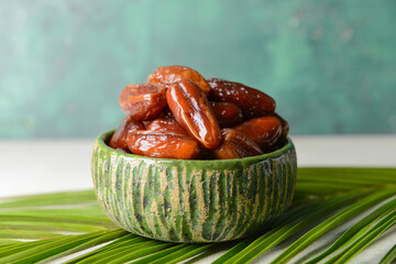 Bowl with sweet dates on table