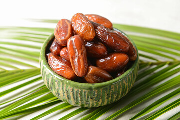Bowl with sweet dates on table
