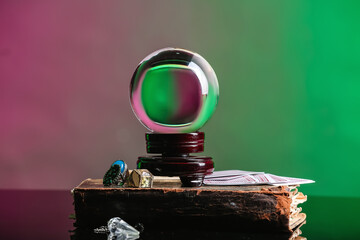 Crystal ball of fortune teller, old book and cards on table